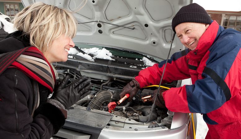 Good Samaritan giving a stranded woman's car a jump start.