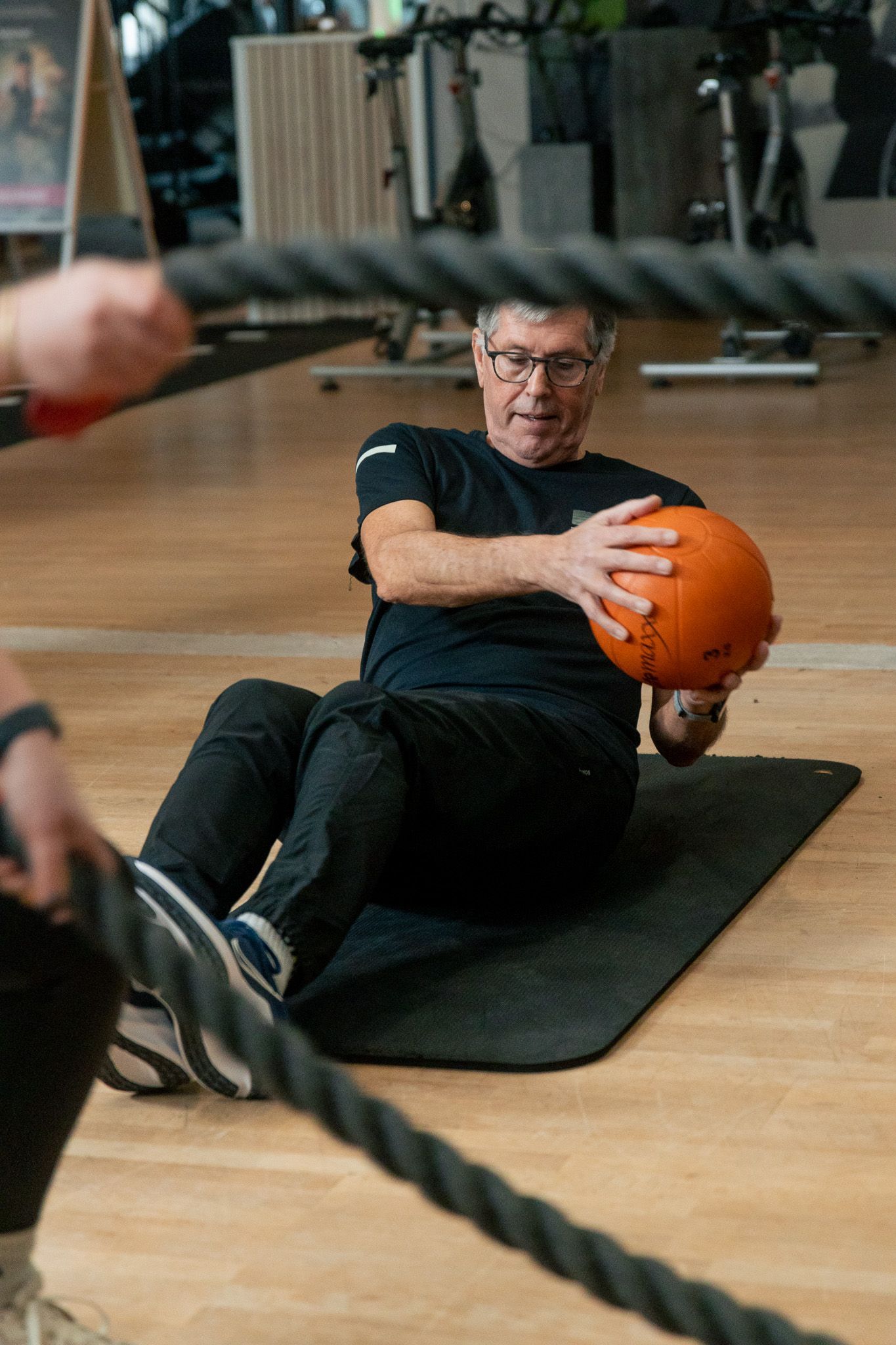 een persoon houdt twee halters vast in een sportschool.