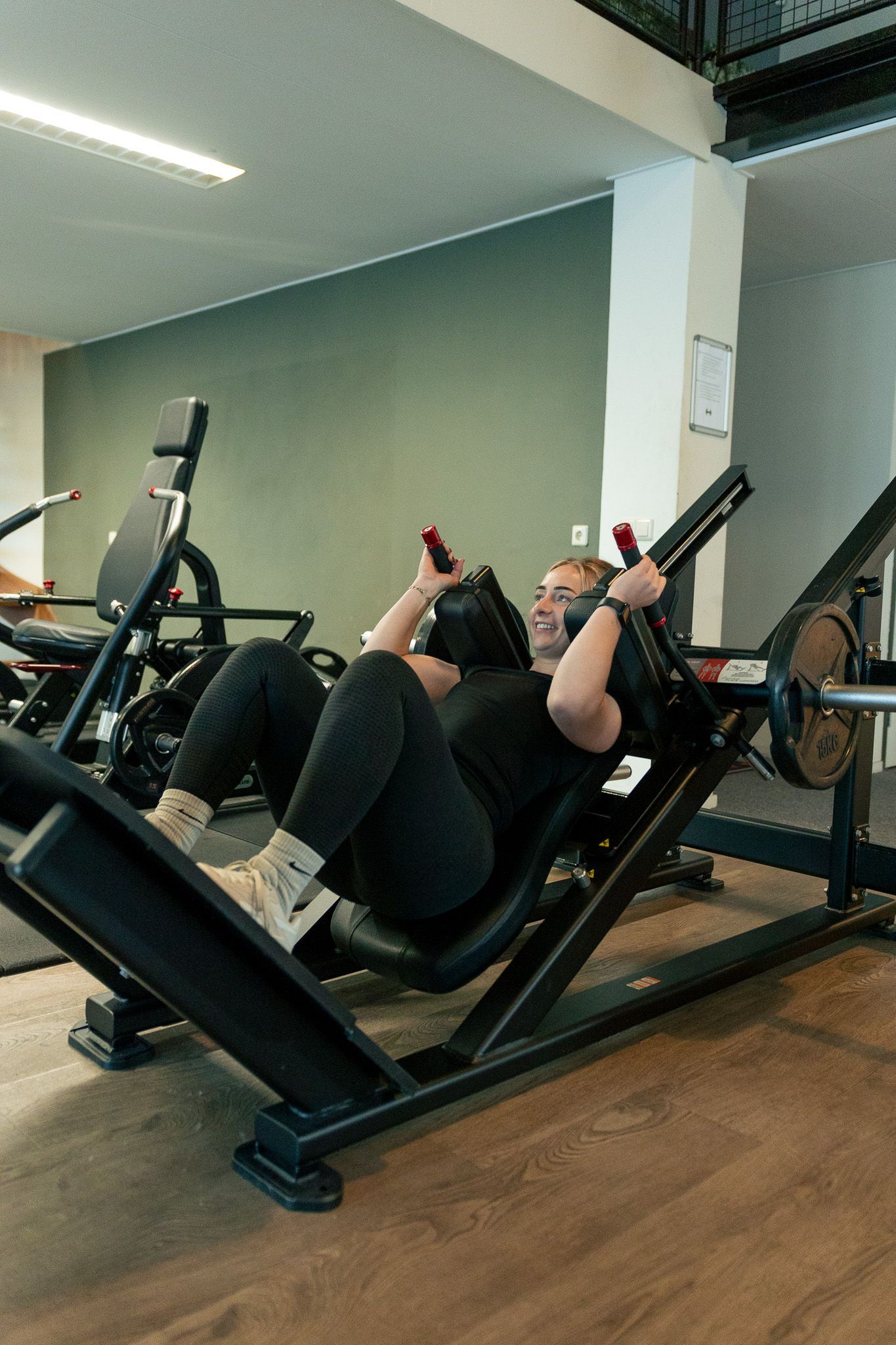 een persoon houdt twee halters vast in een sportschool.