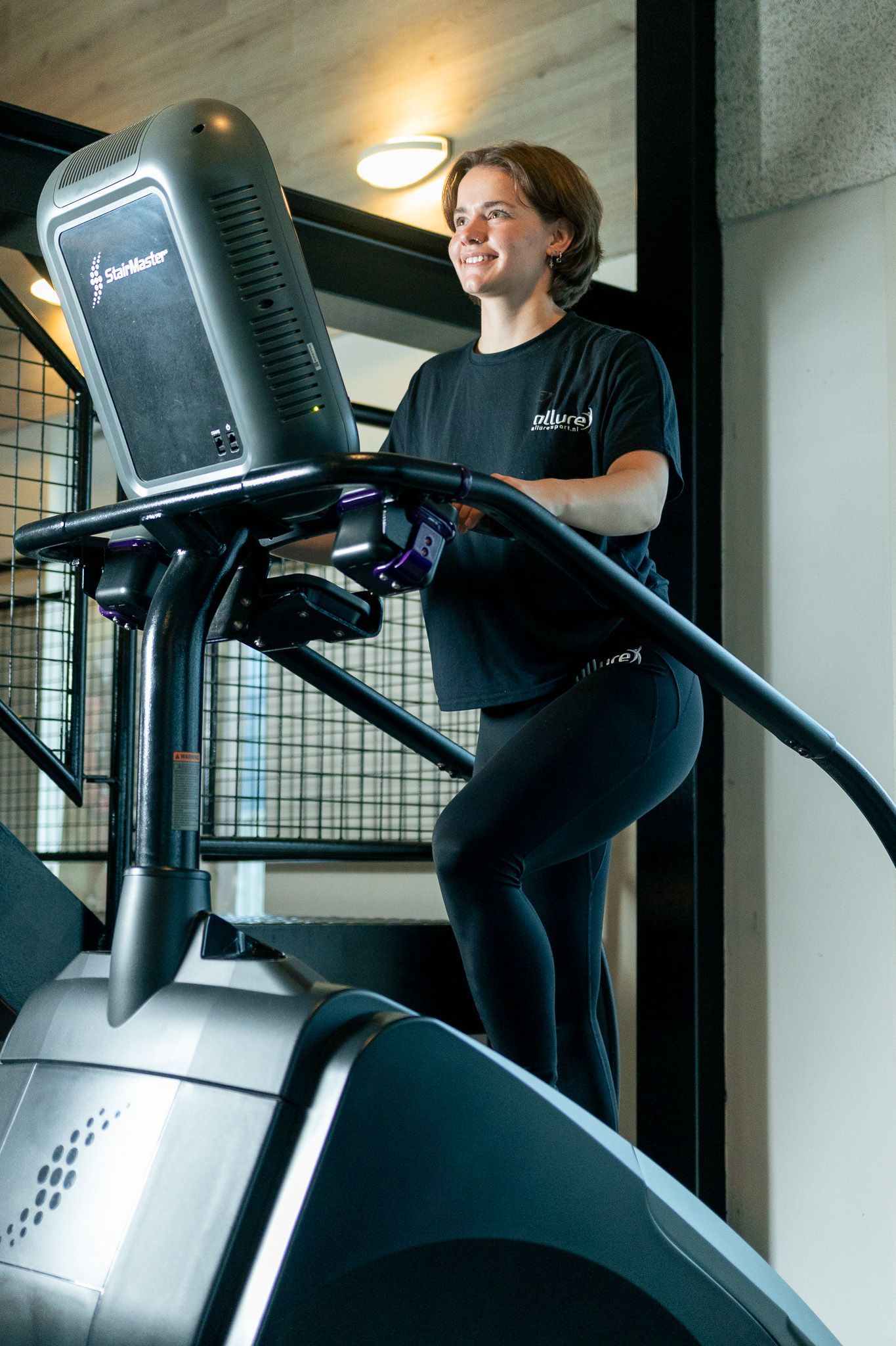 een persoon houdt twee halters vast in een sportschool.