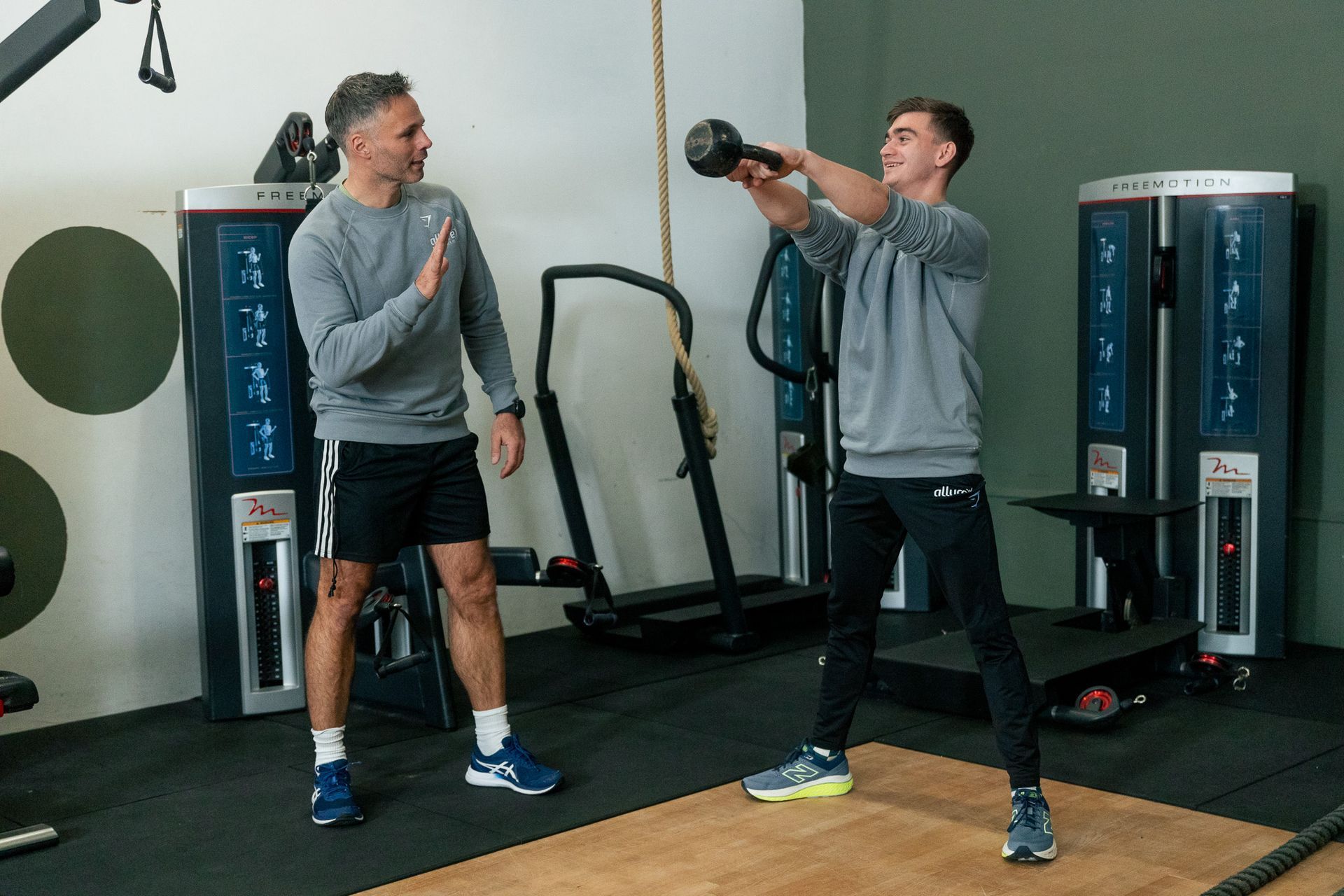een vrouw hurkt met een halter in een sportschool.