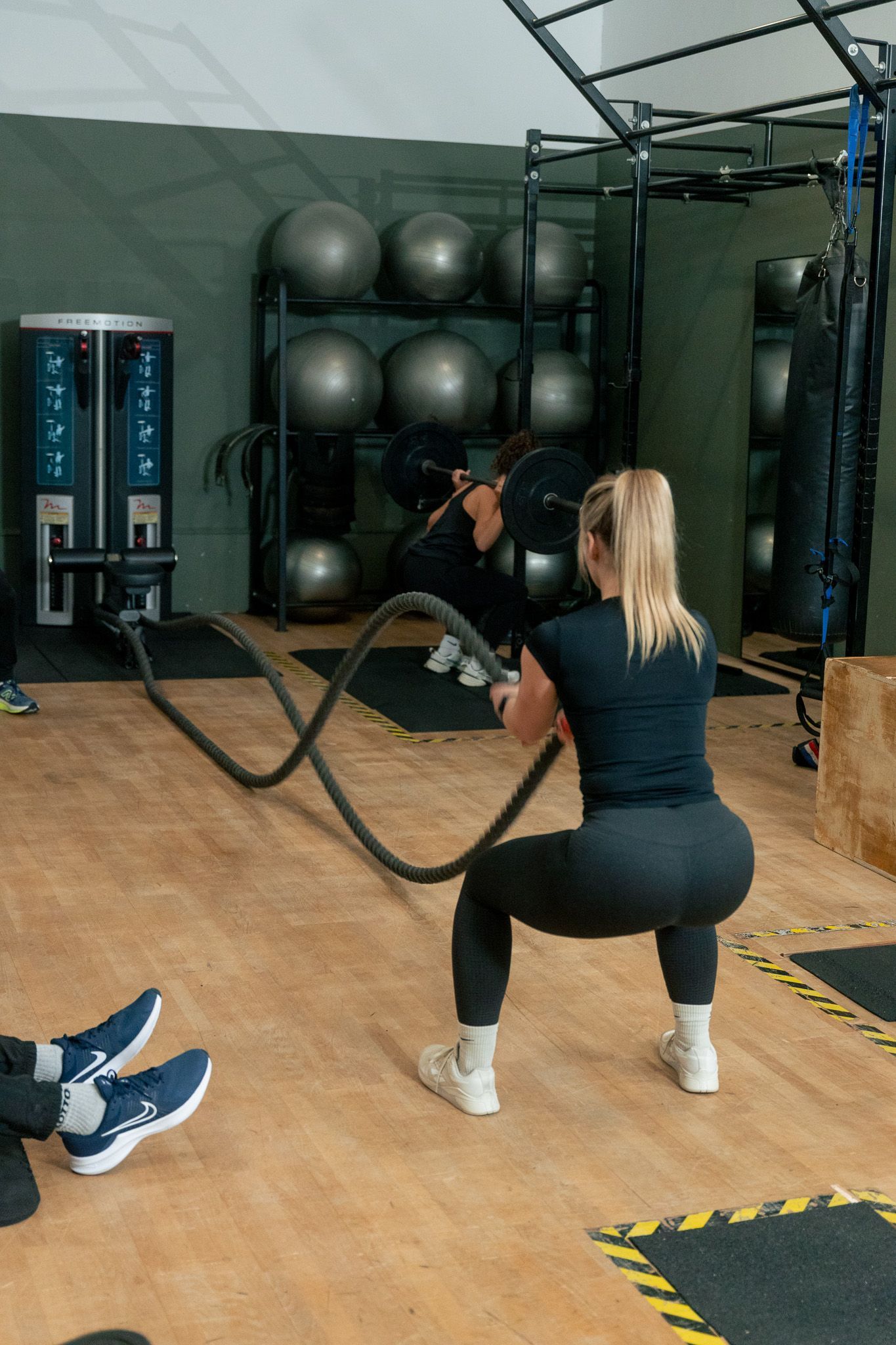 een groep mensen doet kettlebell-oefeningen in een sportschool.