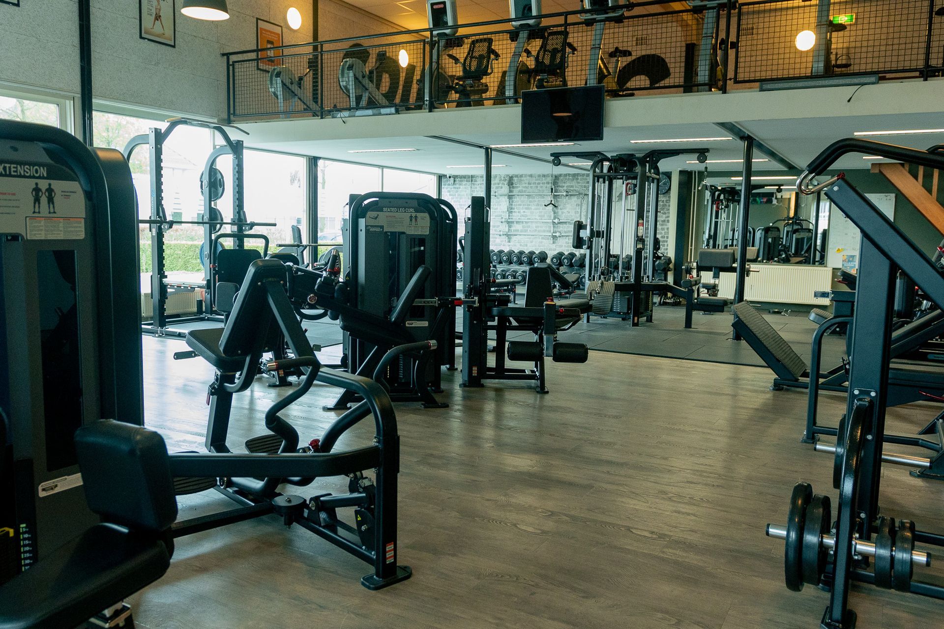 Een grote sportschool vol met fitnessapparatuur.