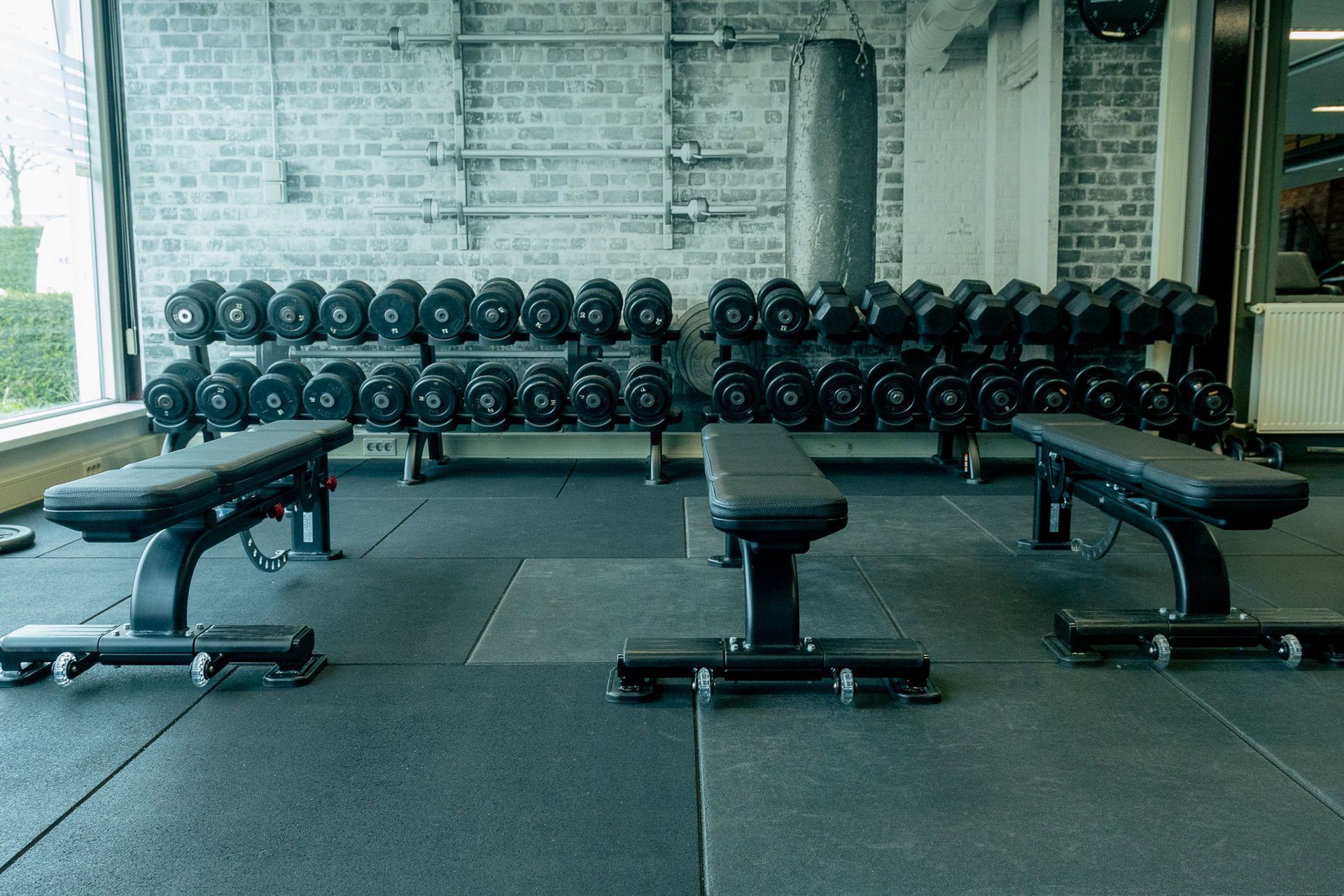 Een sportschool met veel halters en banken