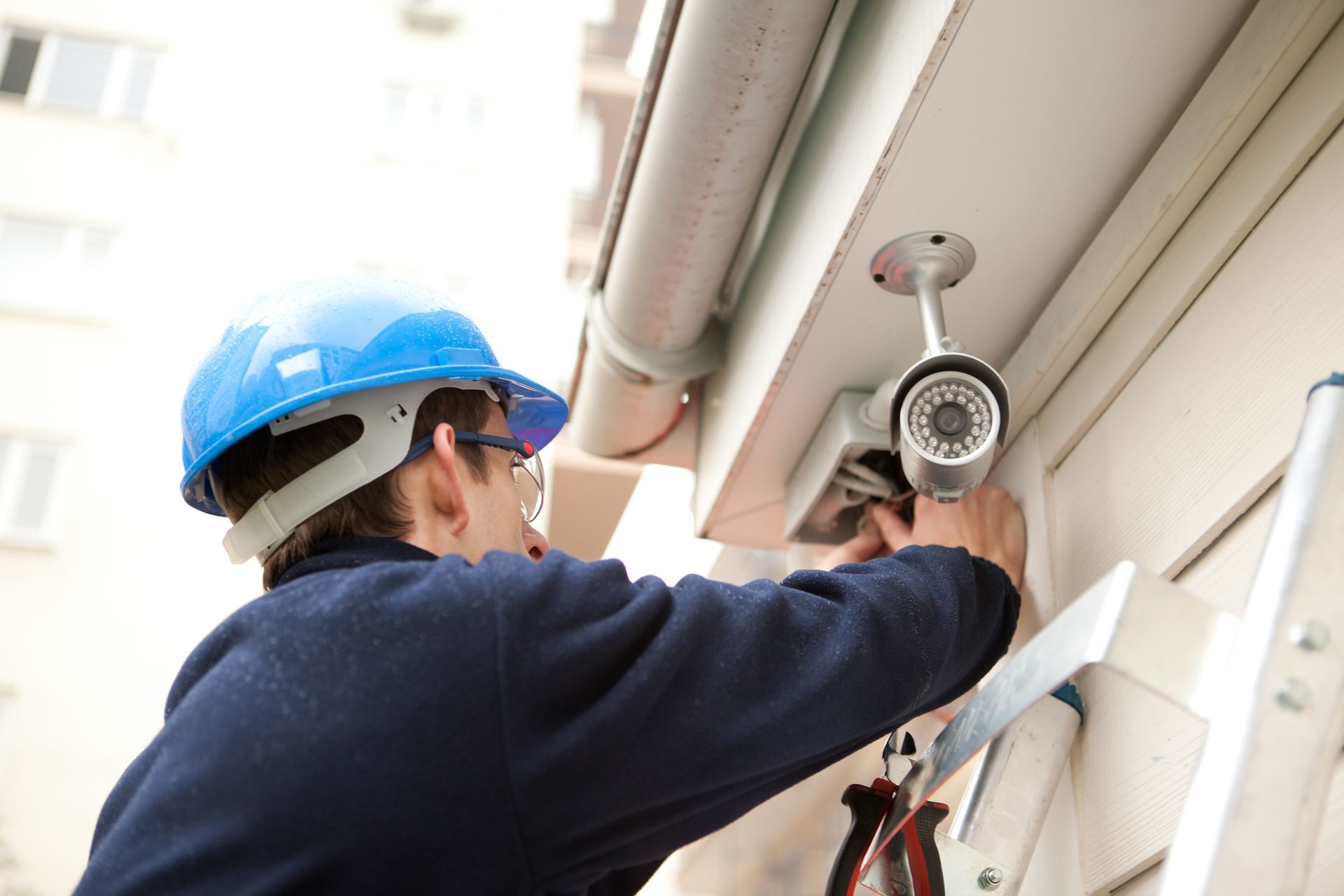 A man is finishing the installation of a security system.