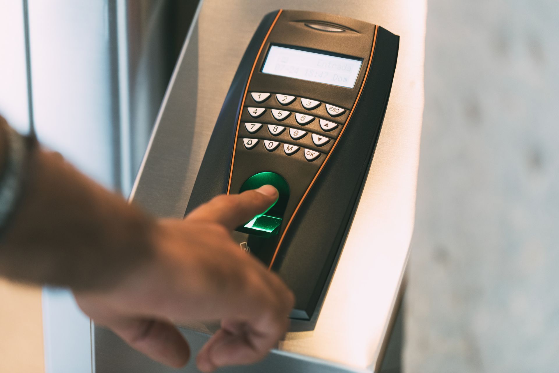 A close-up of an employee's finger scanning a print to record work hours.