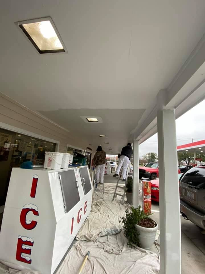 A group of people are painting the ceiling of a building.