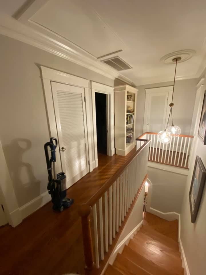 There is a vacuum cleaner on the stairs in the hallway.