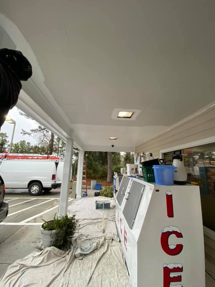 A man is standing on a porch next to a sign that says ice cream.