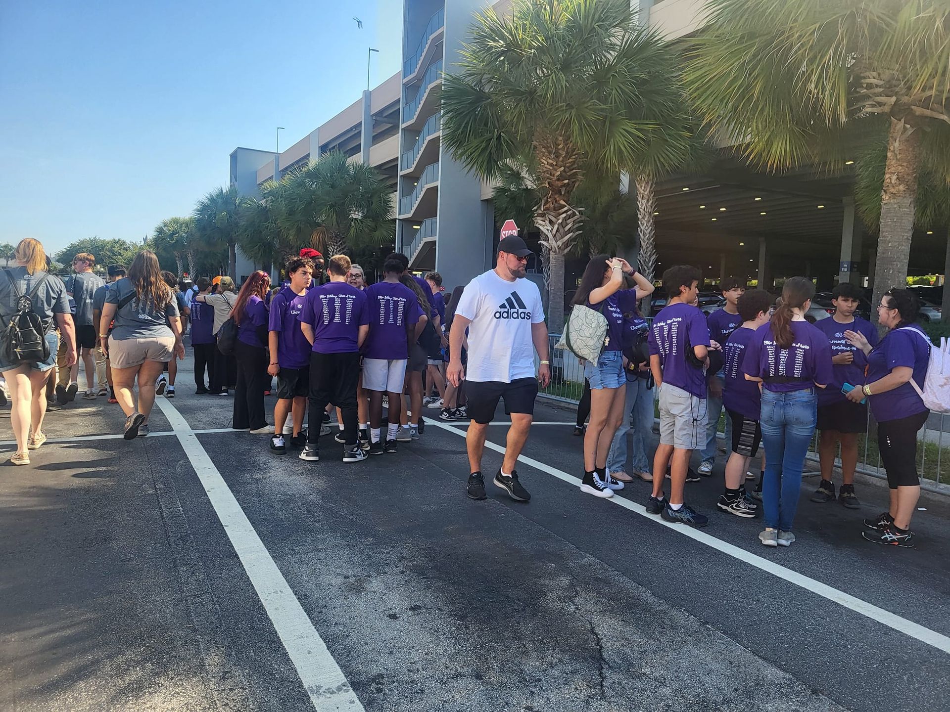 a group of people are standing on the side of the road