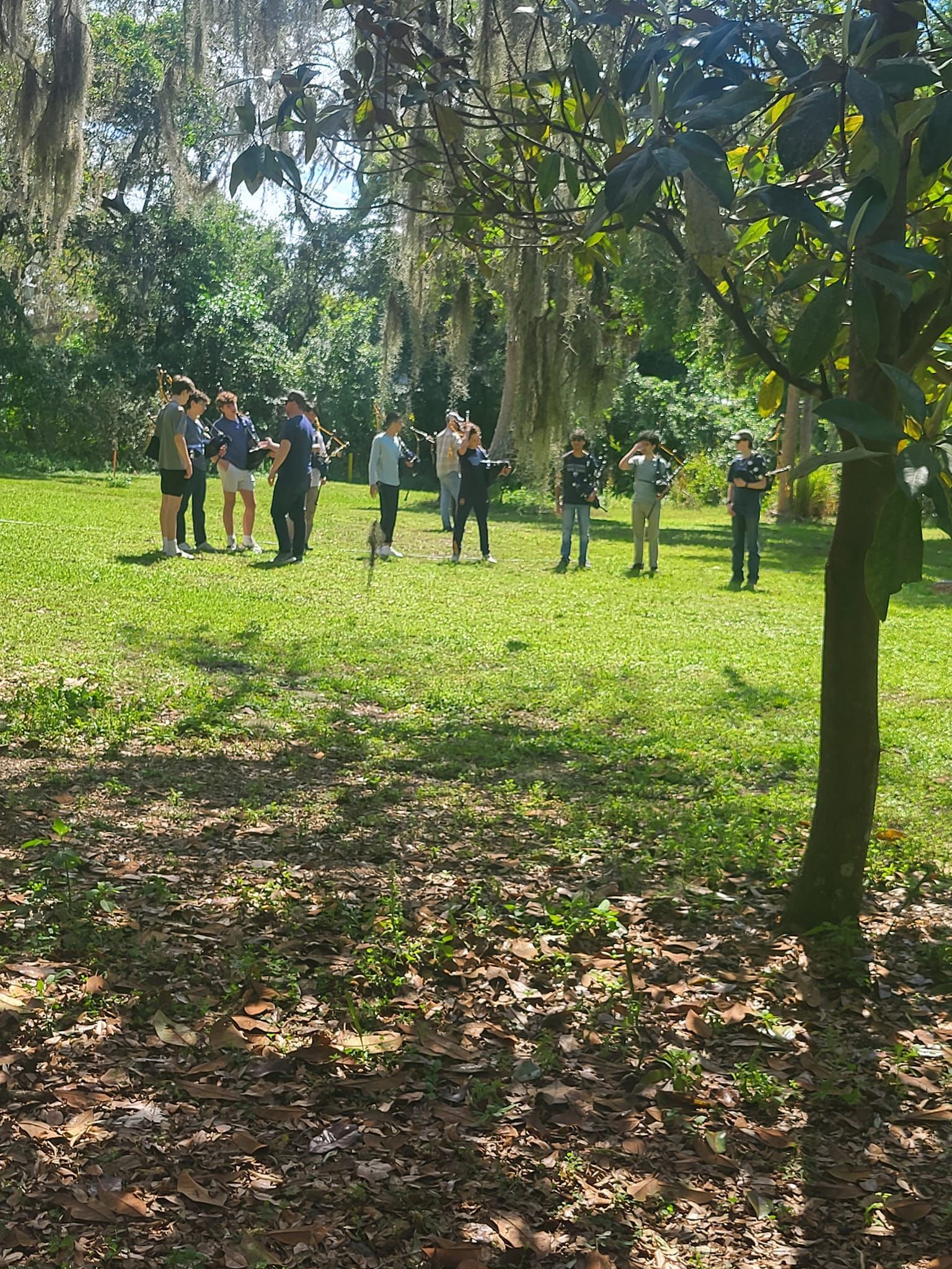 a group of people are standing in a grassy field