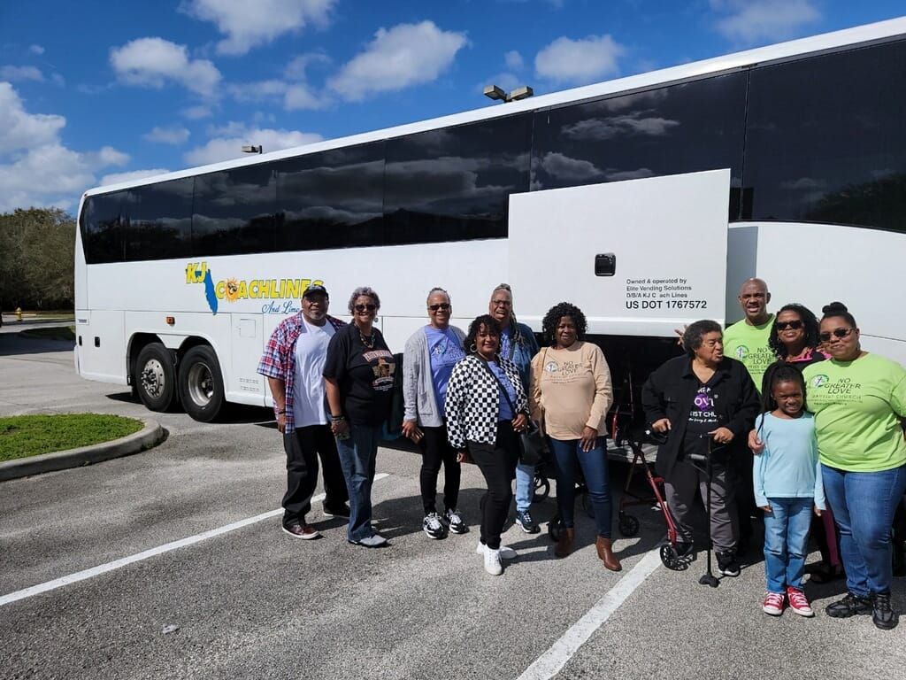 a group of people are posing for a picture in front of a bus