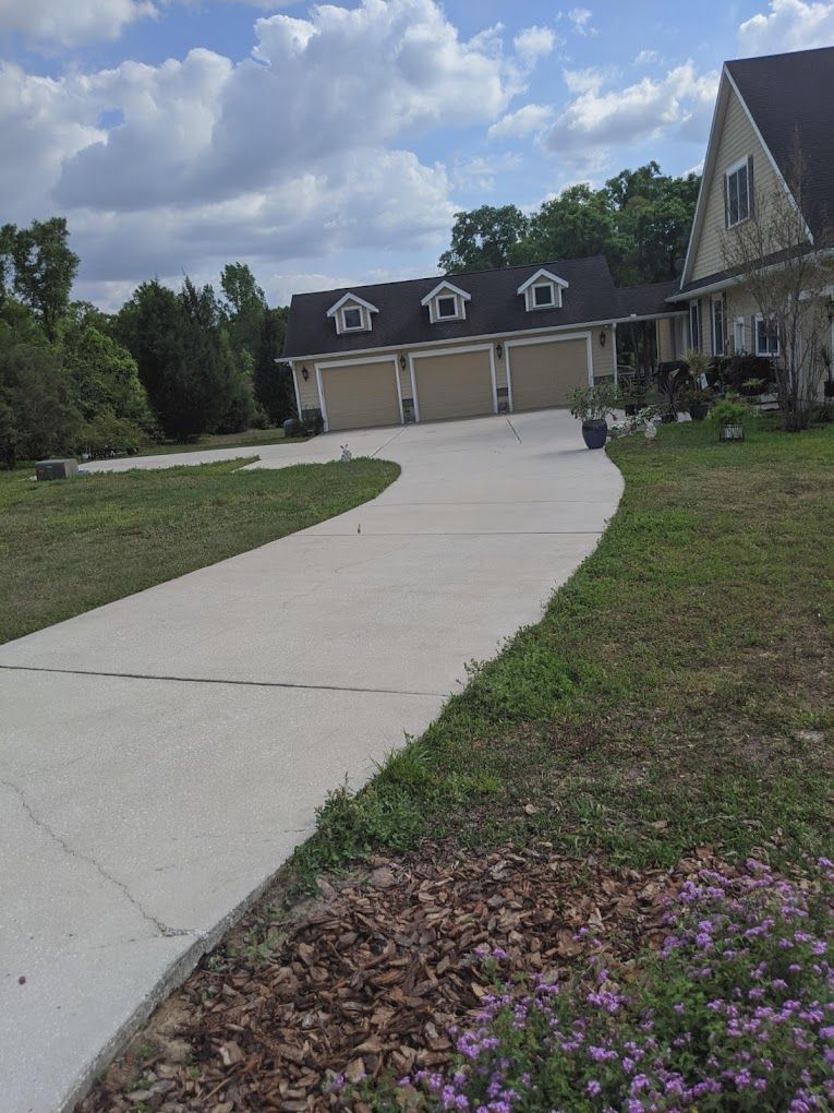 A driveway leading to a house with three garages