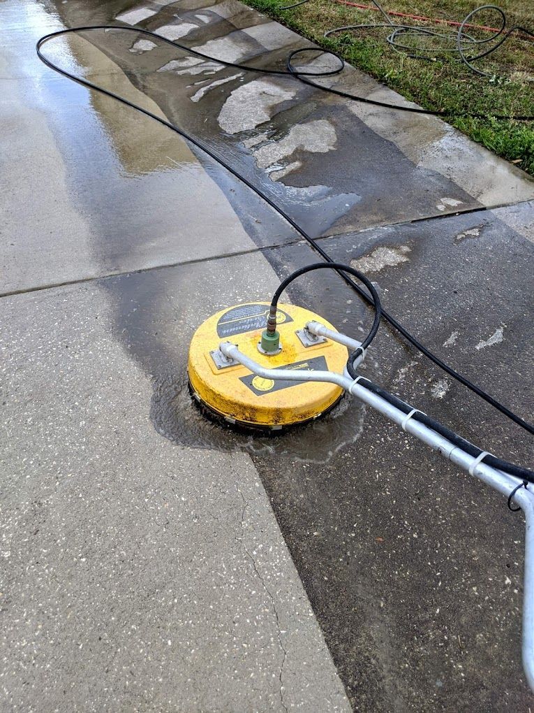A yellow machine is being used to clean a sidewalk.