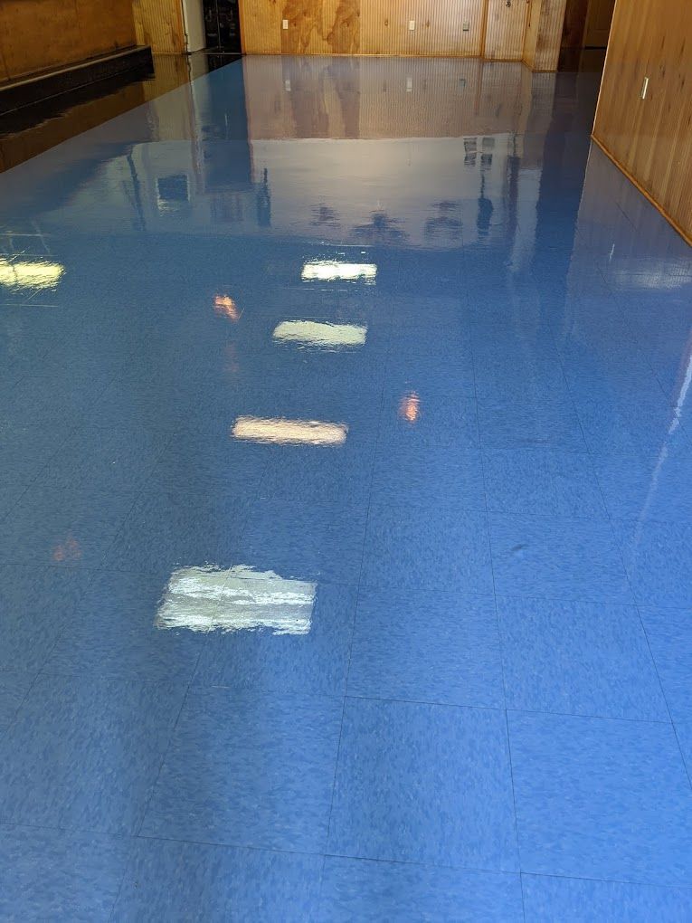 A blue floor with a lot of lights reflected in it.