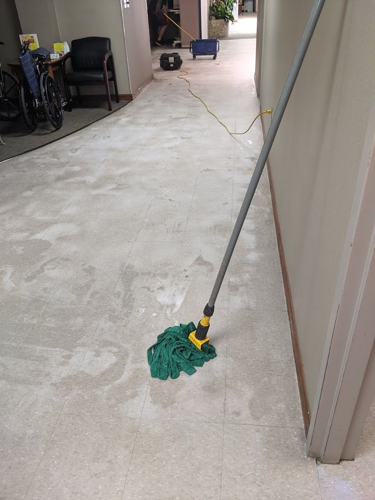 A mop is sitting on the floor in a hallway.