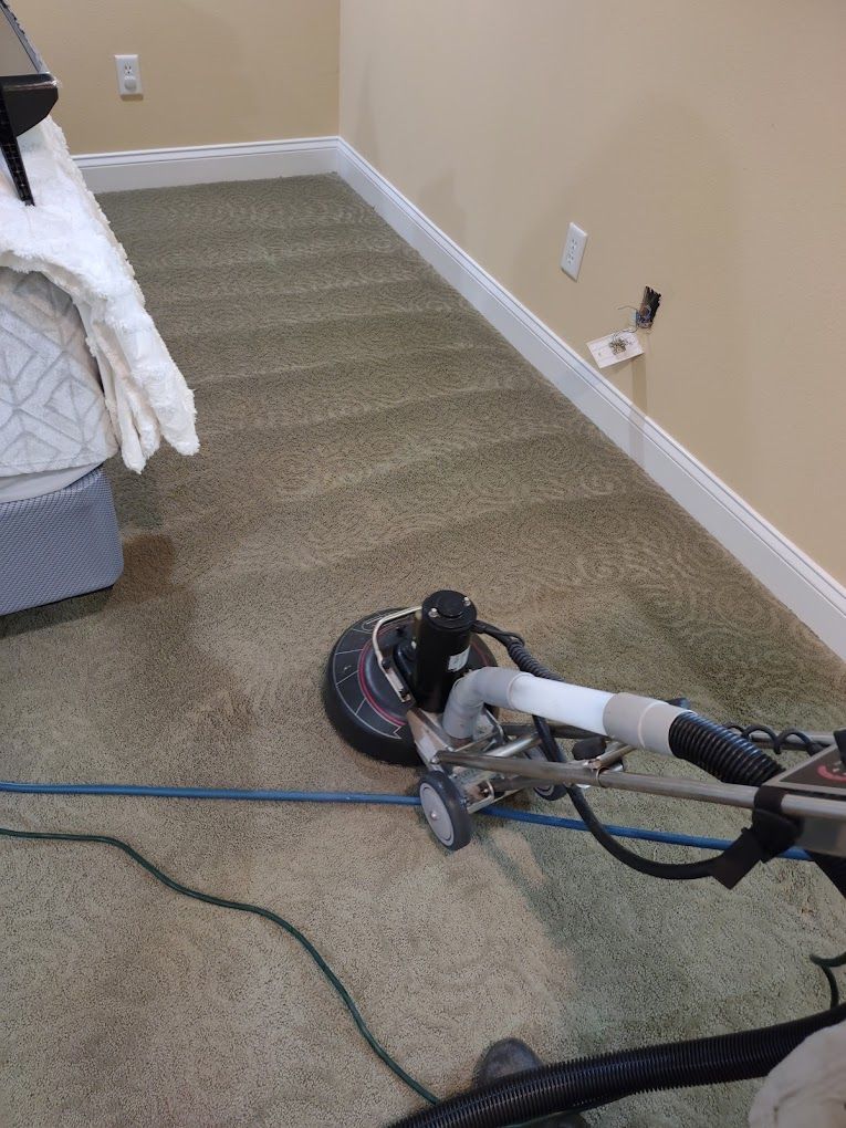 A machine is being used to clean a carpet in a bedroom.