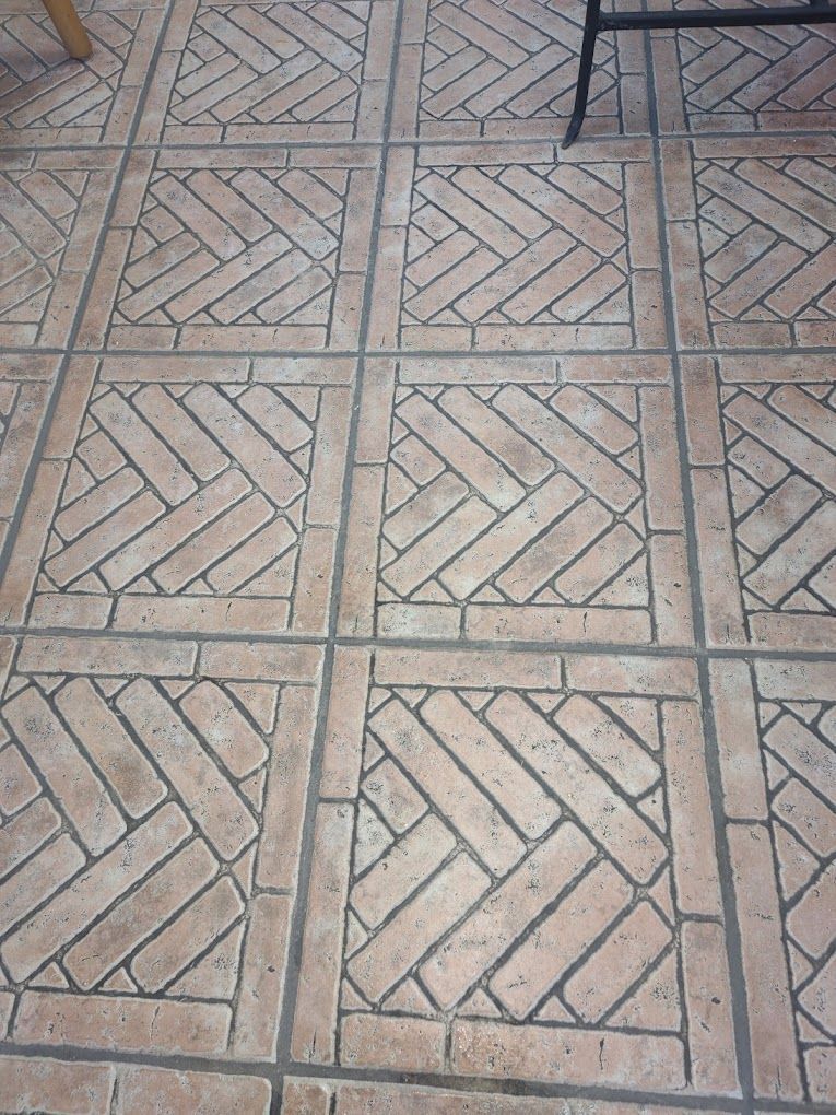 A close up of a tiled floor with a herringbone pattern