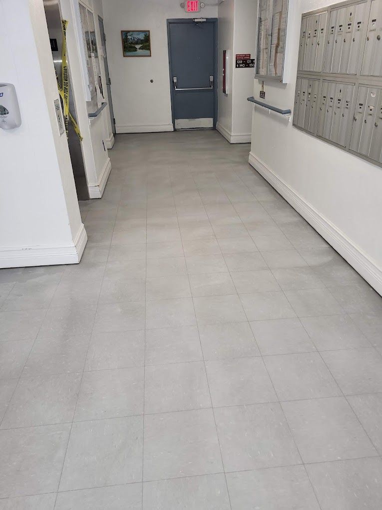 A long hallway with a tiled floor and a door.