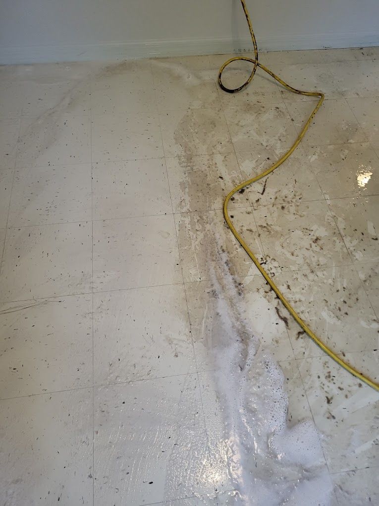 A dirty floor with a yellow cord hanging from it.