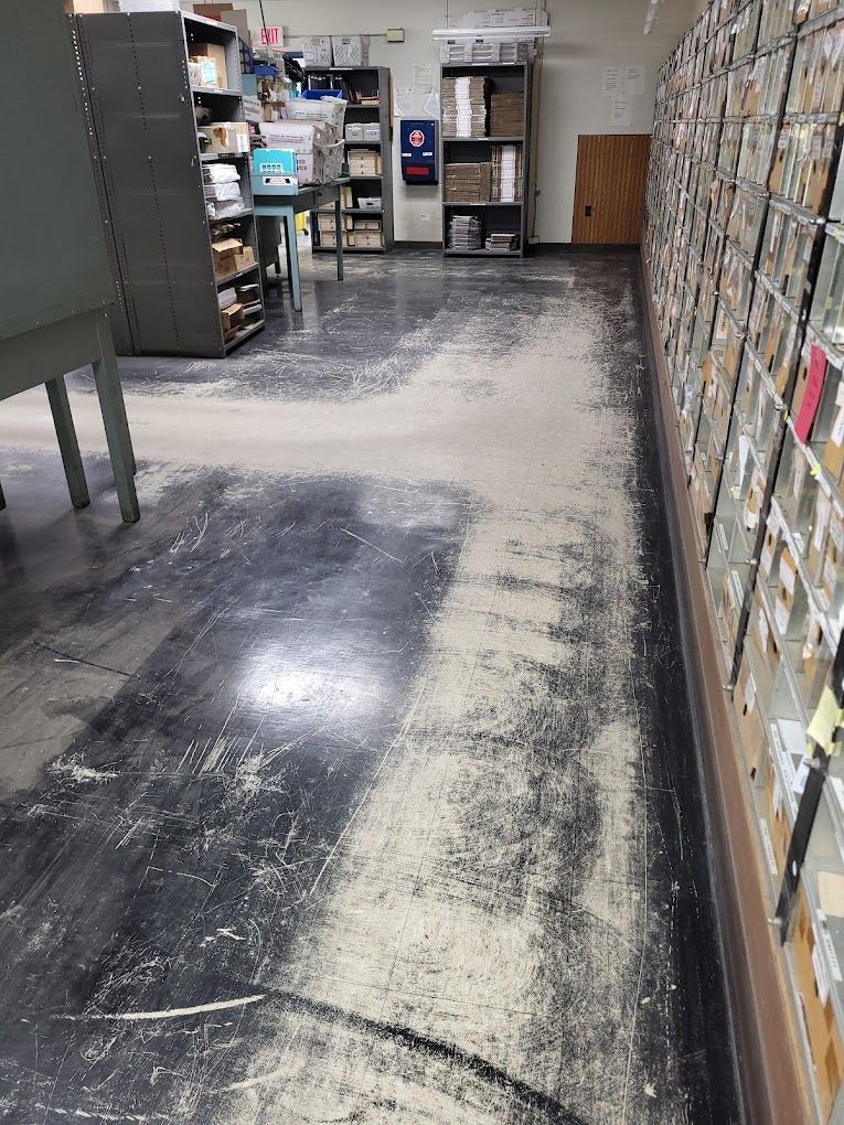 A room with a lot of shelves and a lot of dust on the floor