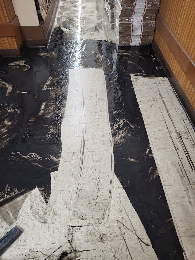 A black and white tile floor in a hallway.