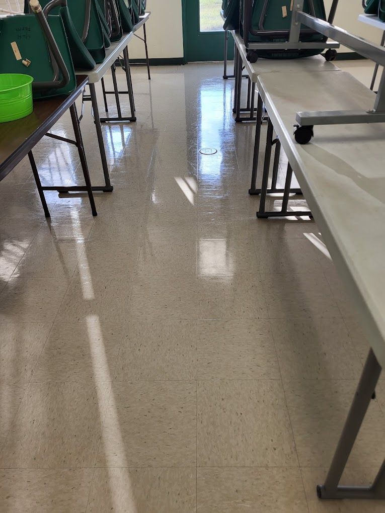 A row of folding tables and chairs in a classroom.