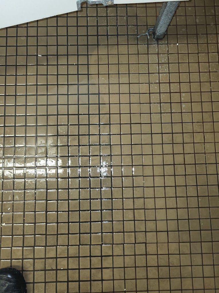 A person is standing on a tiled floor in a bathroom.