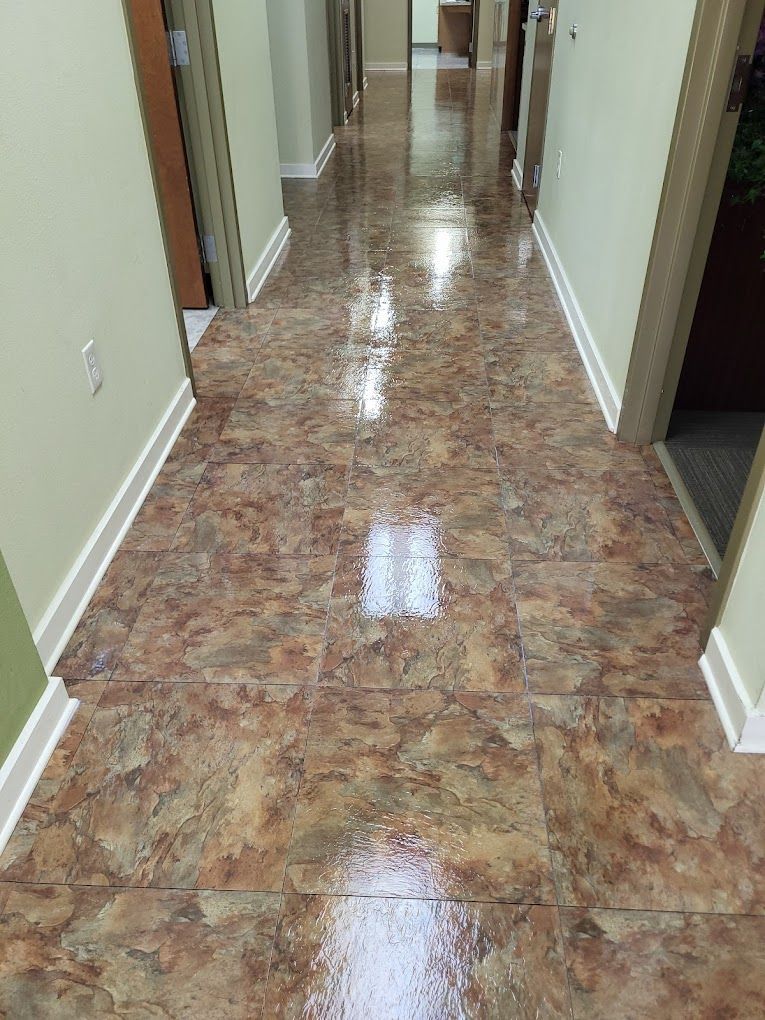 A hallway with a tiled floor and a shiny floor.