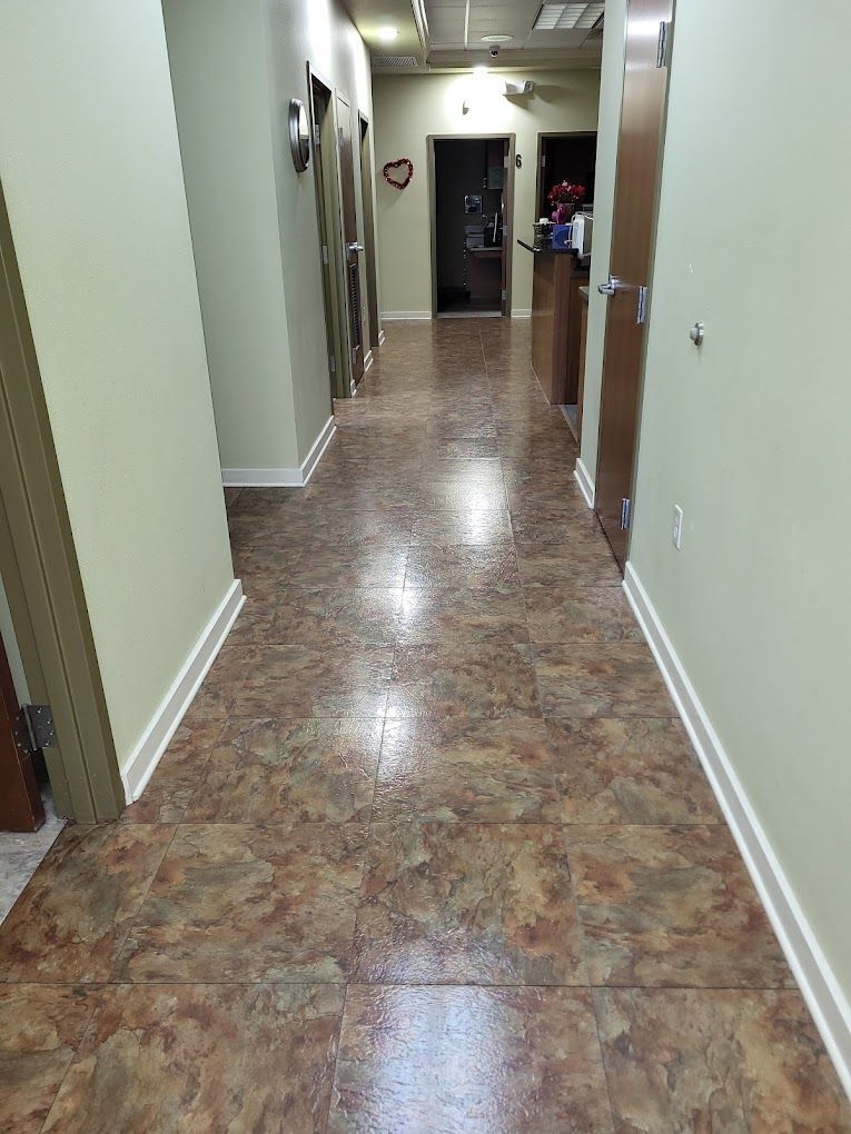 A long hallway with a tiled floor in a building.
