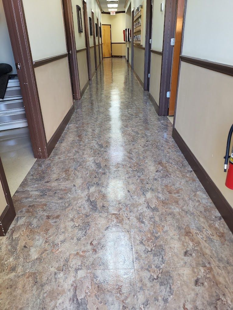 A long hallway with a fire extinguisher in the corner.