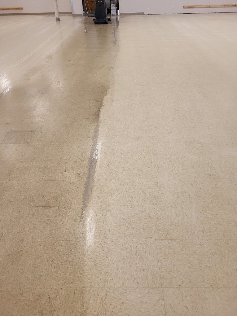 A close up of a dirty and clean floor in a room.