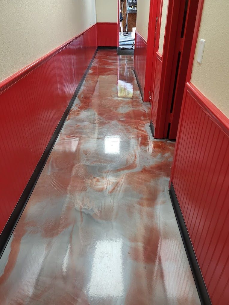 A hallway with red walls and a shiny metallic floor.