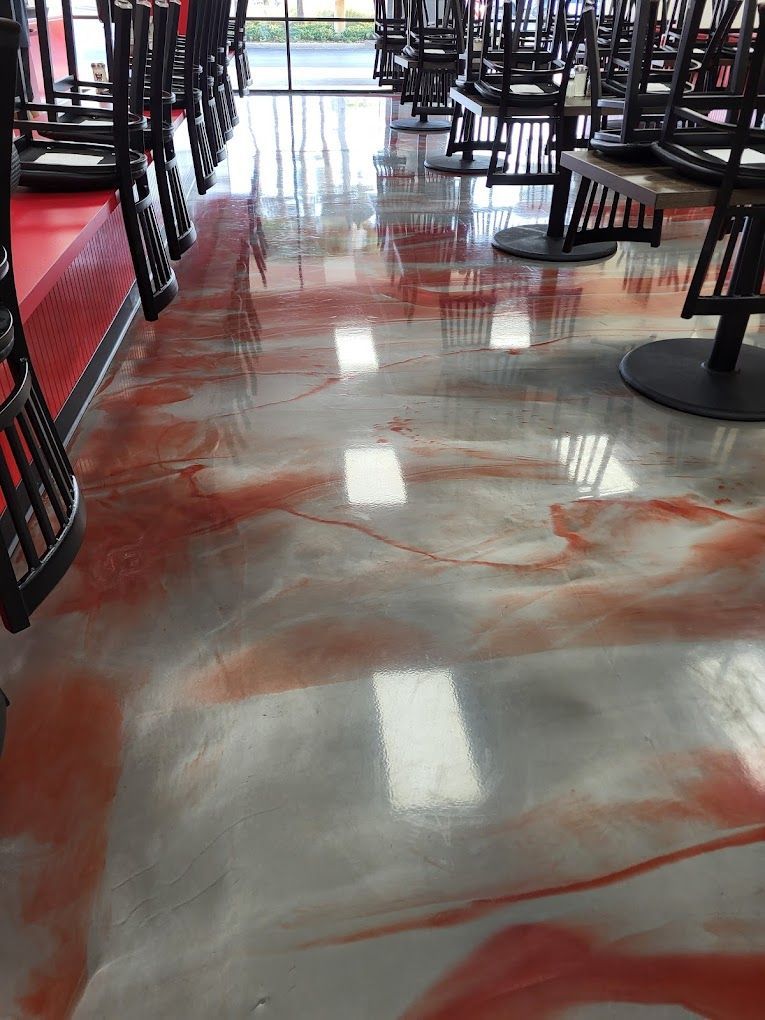 A restaurant with tables and chairs on the floor.