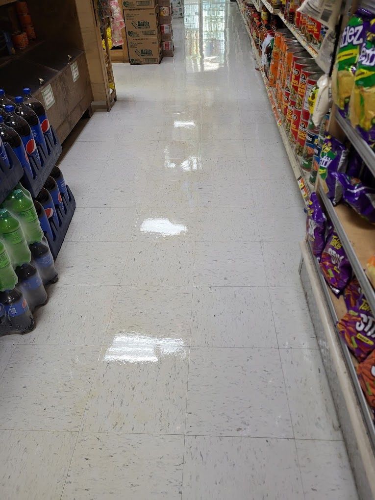 A grocery store aisle filled with bottles of soda and chips.