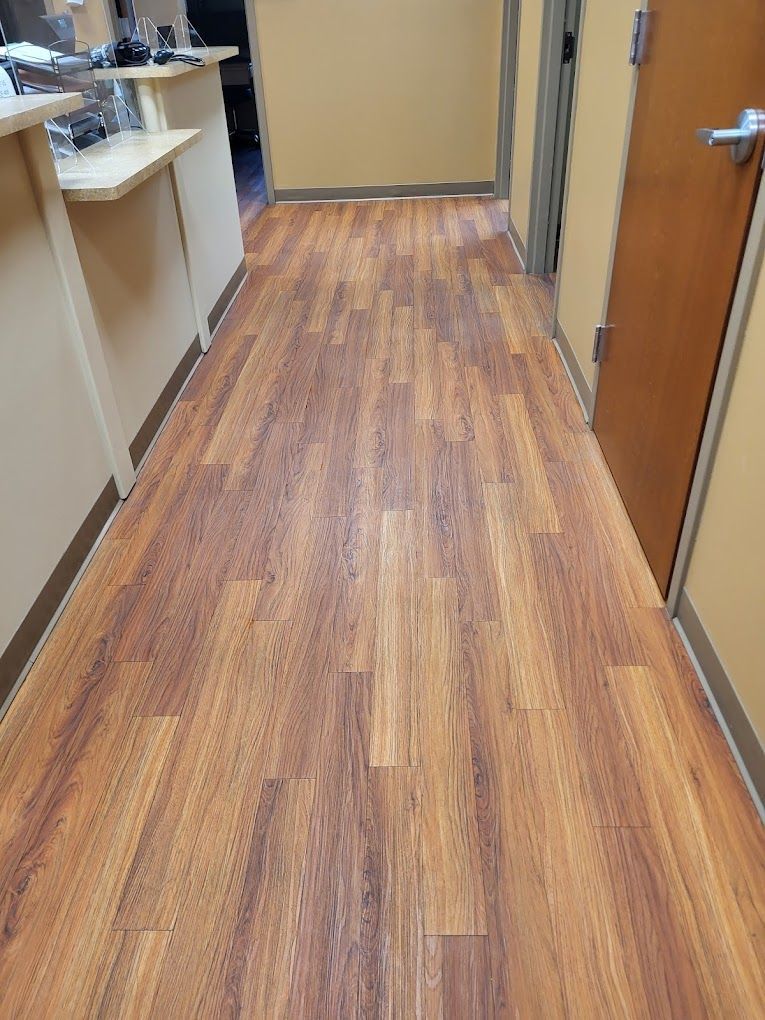 A long hallway with wooden floors in a hospital.
