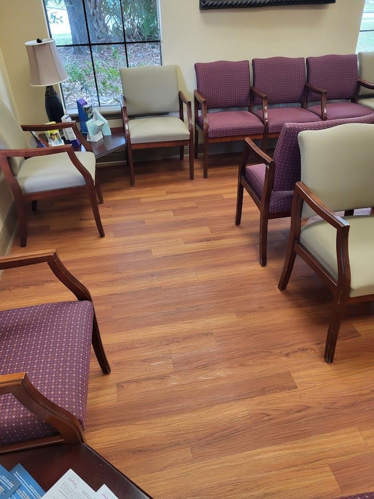 A waiting room with wooden floors and purple chairs