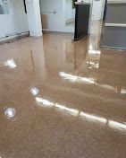 A shiny floor in a room with a counter in the background.