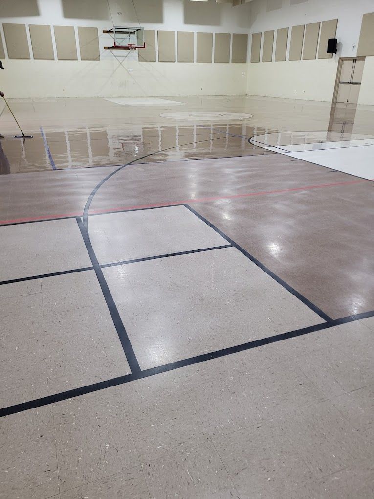 An empty basketball court with a basketball hoop in the background