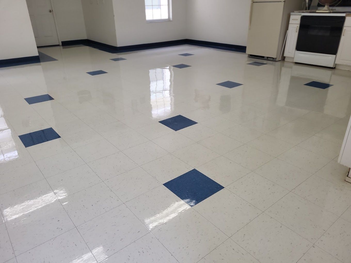 A kitchen with a blue and white tile floor and a stove.