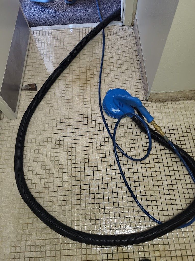 A vacuum cleaner is being used to clean a tiled floor