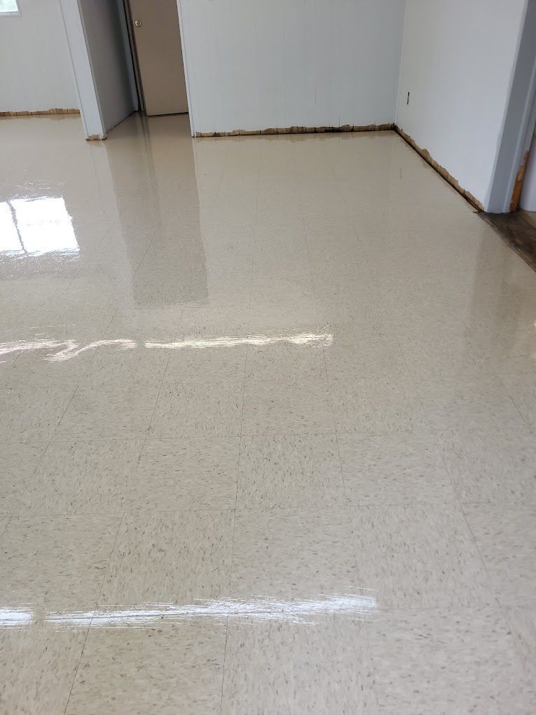 A room with a shiny white floor and white walls.