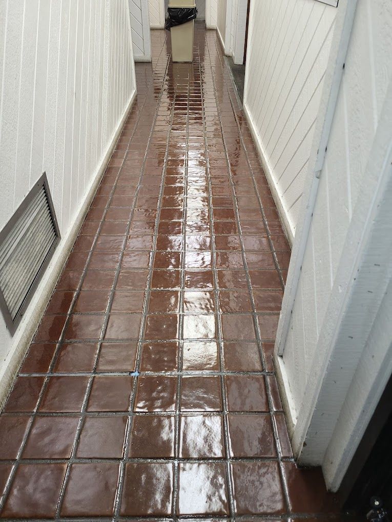 A hallway with brown tiles and white walls