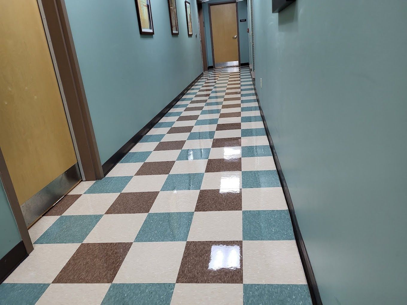 A long hallway with a checkered floor in a building
