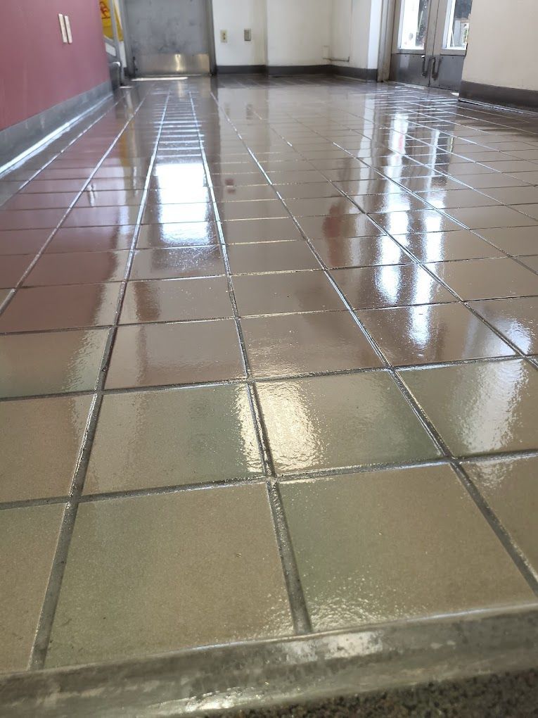 A tiled floor in a room with a door in the background.