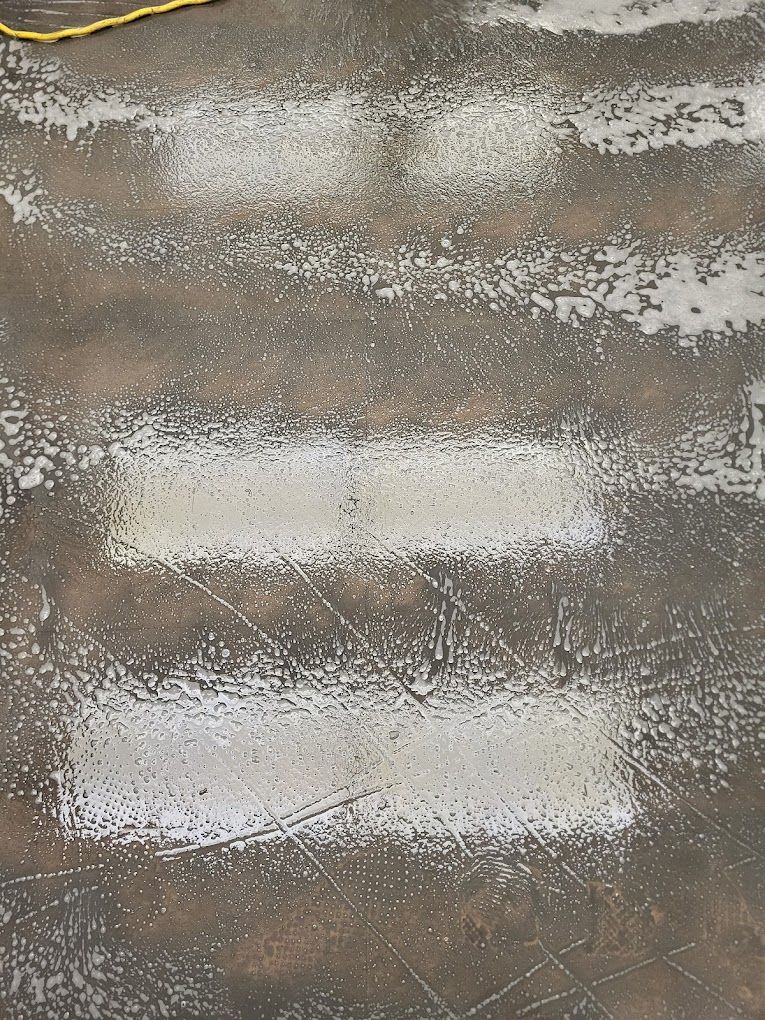 A close up of a concrete floor with white spots on it.