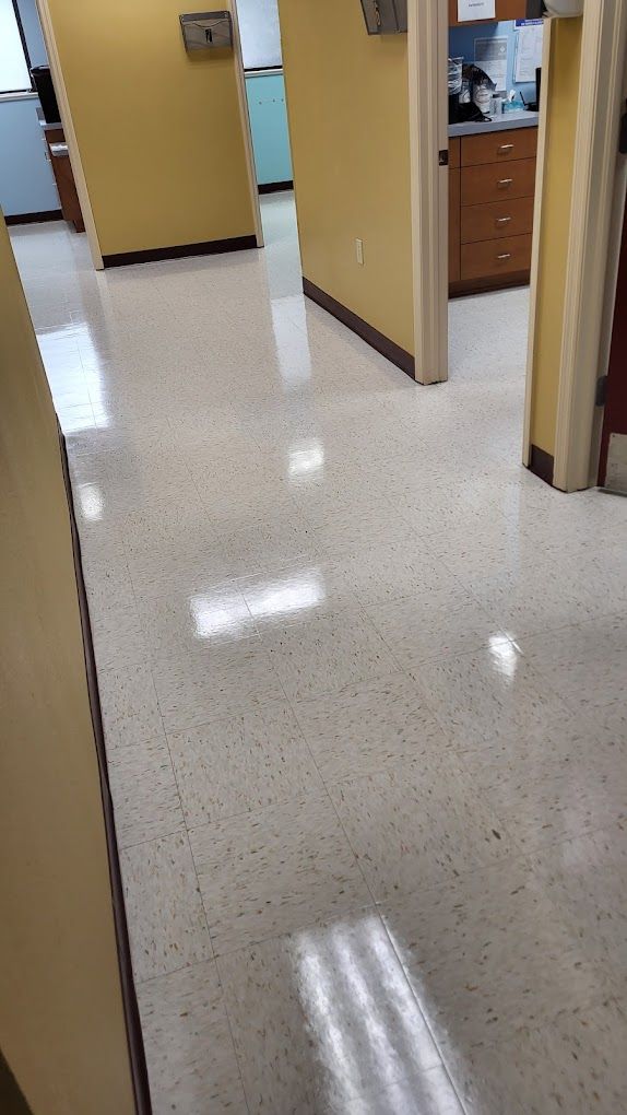 A hallway in a building with a shiny floor and yellow walls.