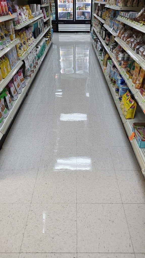 A long aisle in a grocery store filled with shelves of food.