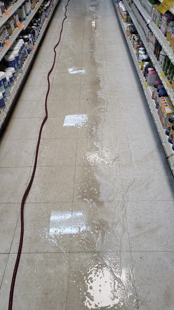 The floor of a grocery store is covered in water.