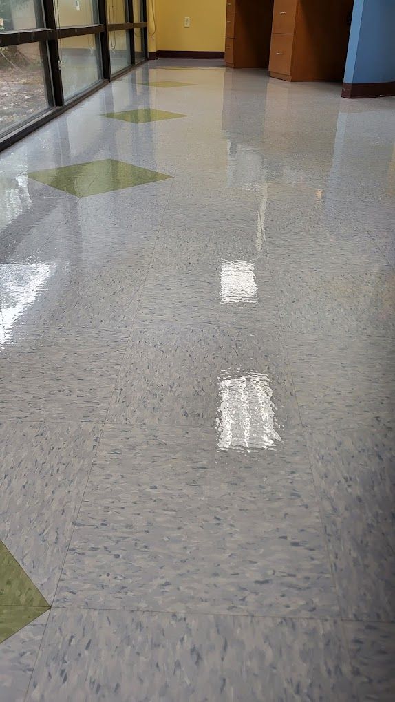 A hallway with a shiny tile floor and a window.